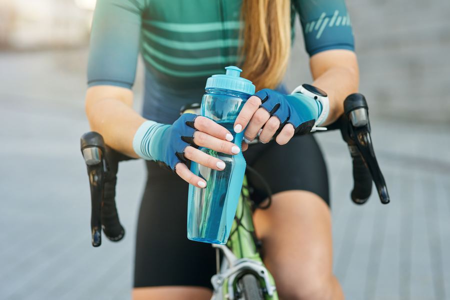 Radfahrerin mit Trinkflasche macht Pause